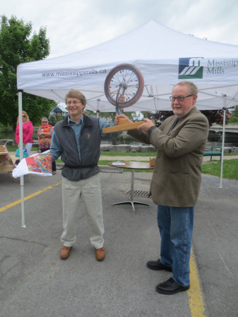 Ottawa Councillor David Chernushenko (left), winner of the Mayor’s Slow Bike Race, received the trophy and a Bicycle Month t-shirt from Jeff Mills of the Mills Community Support Corporation.